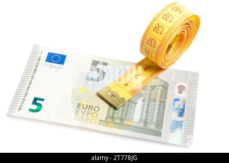 Rolle Maßband auf neuer 5-Euro-Banknote auf weißem Hintergrund Stockfoto
