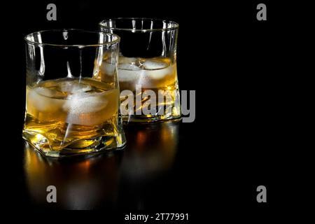 Zwei Gläser Whiskey mit Eis mit Platz für Text auf schwarzem Hintergrund Stockfoto
