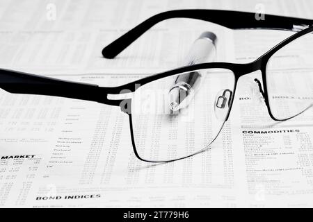 Brillen über Finanzzeitung in der Nähe eines Geschäftsbuches Stockfoto