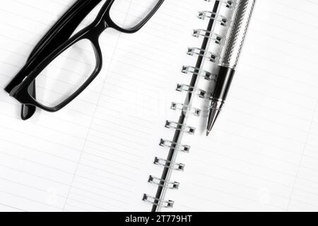 Ansicht von oben auf Glas und Schreibstift auf dem Notebook Stockfoto