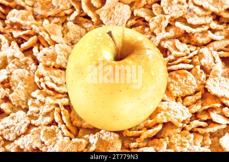 Gelber Apfel auf Cornflakes Hintergrund, Diätkonzept Stockfoto