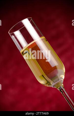 Flöte aus goldenem Champagner auf rotem Bokeh-Hintergrund Stockfoto