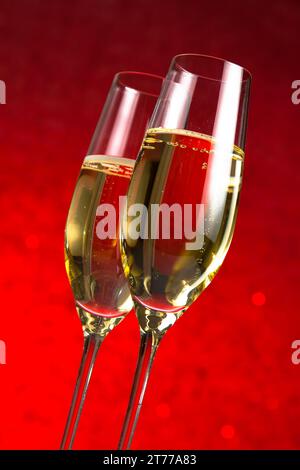 Ein Paar Sektflöten auf rotem Bokeh-Hintergrund Stockfoto
