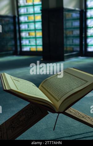 Vertikales Foto mit islamischem Hintergrund. Der heilige Koran auf dem Rednerpult in einer Moschee. Ramadan kareem oder eid mubarak oder laylat al-qadr oder kadir gecesi Konzept Stockfoto