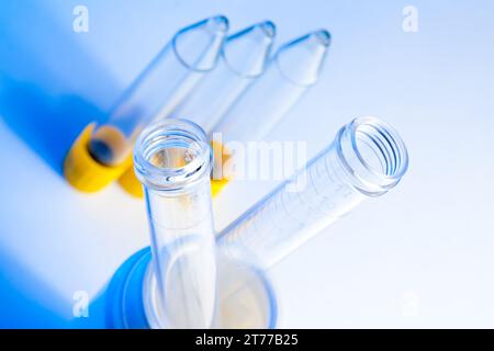 Detail der Reagenzgläser im Labor auf Tisch und blauhellblauem Hintergrund Stockfoto