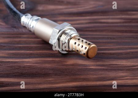 Sauerstoffsensor für Benzin- und Dieselmotoren auf Holztisch. Die Lambdasonde ist eine zuverlässige Komponente zur Optimierung der Leistung Ihres Fahrzeugs. Stockfoto