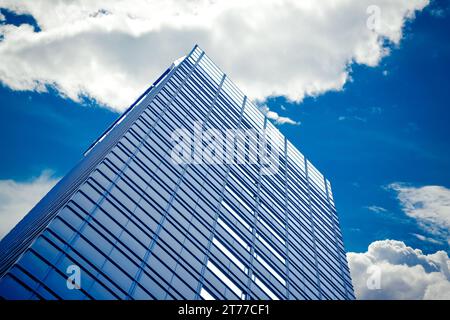 Wolkenkratzer mit Wolken unter blauem Himmel; Wolkenkratzer mit Wolken unter blauem Himmel Stockfoto