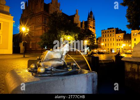 04-07-2022: Bronze-vergoldete Froschskulptur, die Wasser gießt, Detail eines Brunnens. Abend in Torun, Polen. Stockfoto