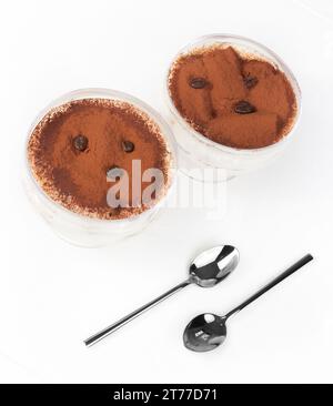 italienisches Tiramisu-Dessert in einer Tasse mit Kaffeebohnen auf weißem Tisch Stockfoto