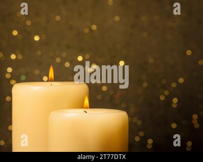 Kerzen mit Flamme auf goldenem Bokeh-Hintergrund und Platz für Text Stockfoto