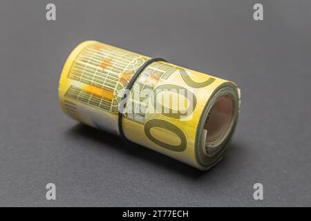 Rolle zweier handerd-Euro-Banknoten auf dunklem Hintergrund in Nahaufnahme Stockfoto