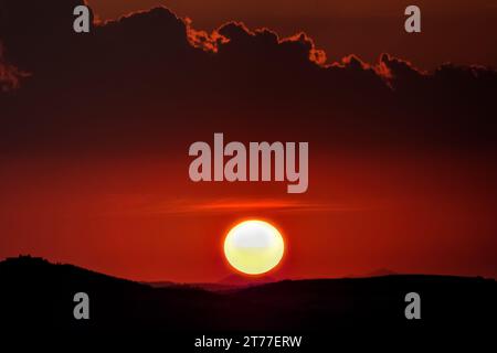 Roter Sonnenuntergang mit Sonne und Silhouette Hintergrund Stockfoto