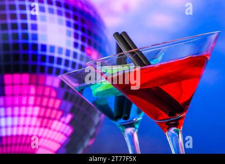 Blauer und roter Cocktail mit funkelndem Discoball Hintergrund mit Platz für Text, Tanzdisco-Konzept Stockfoto