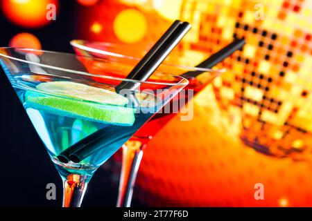 Blauer und roter Cocktail mit funkelndem Discoball Hintergrund mit Platz für Text, Tanzdisco-Konzept Stockfoto