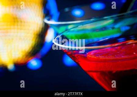 Detail des roten Cocktails mit goldenem funkelndem Discoball Hintergrund mit Platz für Text, Tanzdisco-Konzept Stockfoto