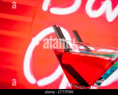 Detail eines roten Cocktails mit Neonhintergrund mit Platz für Text, Tanzdisco-Konzept Stockfoto