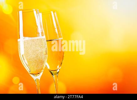 Champagnerflöten mit goldenen Blasen auf goldenem hellen Hintergrund mit Platz für Text Stockfoto