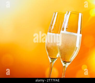 Champagnerflöten mit goldenen Blasen auf goldenem hellen Hintergrund mit Platz für Text Stockfoto