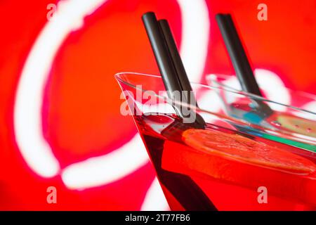 Detail eines roten Cocktails mit Neonhintergrund mit Platz für Text, Tanzdisco-Konzept Stockfoto