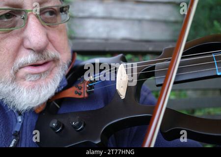Porträt eines älteren Mannes, der eine elektrische Violine spielt Stockfoto