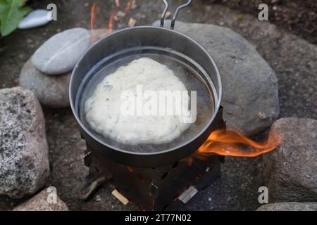 Bannock, Bannockbrot, Bannock-Brot, Pfannenbrot, Fladenbrot, Brot, wird auf offenem Feuer, Lagerfeuer, Hobo-Kocher, Outdoor-Kocher, Campingkocher selb Stockfoto