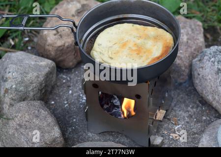 Bannock, Bannockbrot, Bannock-Brot, Pfannenbrot, Fladenbrot, Brot, wird auf offenem Feuer, Lagerfeuer, Hobo-Kocher, Outdoor-Kocher, Campingkocher selb Stockfoto