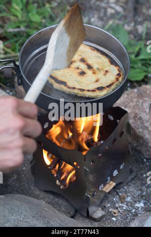 Bannock, Bannockbrot, Bannock-Brot, Pfannenbrot, Fladenbrot, Brot, wird auf offenem Feuer, Lagerfeuer, Hobo-Kocher, Outdoor-Kocher, Campingkocher selb Stockfoto