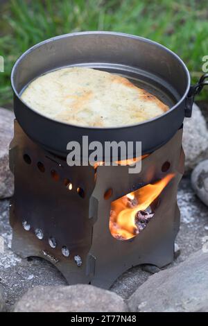 Bannock, Bannockbrot, Bannock-Brot, Pfannenbrot, Fladenbrot, Brot, wird auf offenem Feuer, Lagerfeuer, Hobo-Kocher, Outdoor-Kocher, Campingkocher selb Stockfoto