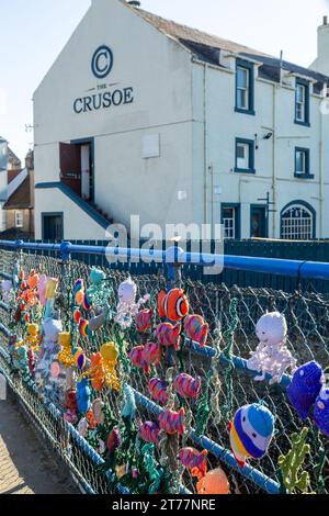The Crusoe Pub & Hotel Largo mit farbenfrohen Strickarbeiten im Vordergrund, Fife, Schottland Stockfoto