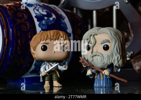 Funko Pop Actionfiguren von Hobbit Sam und Zauberer Gandalf the Grey aus dem Fantasy-Film der Herr der Ringe. Dunkler Palast, blaues Porzellanfass. Stockfoto