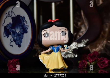 Funko Pop Actionfigur der Disney Prinzessin Schneewittchen mit Vogel. Wunderschöner Palast, fabelhaftes Königreich, Säulen, rote Rosen, Vintage Blue Fass. Stockfoto