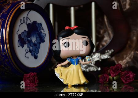 Funko Pop Actionfigur der Disney Prinzessin Schneewittchen mit Vogel. Wunderschöner Palast, fabelhaftes Königreich, Säulen, rote Rosen, Vintage Blue Fass. Stockfoto