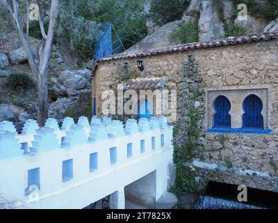 Steinige Gebäude und weiße Brücke über den Ras El Maa Wasserfall in der afrikanischen Stadt Chefchaouen in Marokko am 2019 warmen, sonnigen Frühlingstag im April. Stockfoto