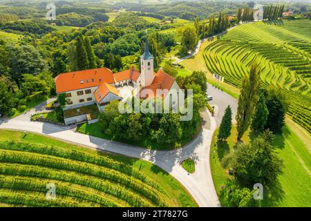 Aus der Vogelperspektive auf die Kirche und die grünen Weinberge, Jeruzalem Weingut, Slowenien Stockfoto