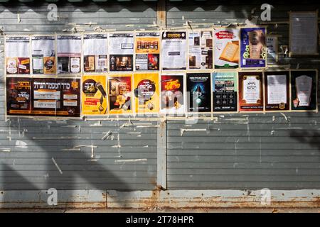 Eine Mauer an der Hooper Street in Williamsburg, die Werbeplakate und Auflistungen von Veranstaltungen enthält, die hauptsächlich in jiddischer Sprache stattfinden. In Brooklyn, New York. Stockfoto