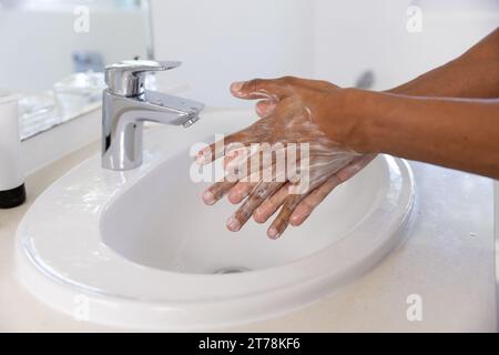 Nahaufnahme eines rassistischen Mannes, der zu Hause im Badezimmer die Hände wäscht Stockfoto