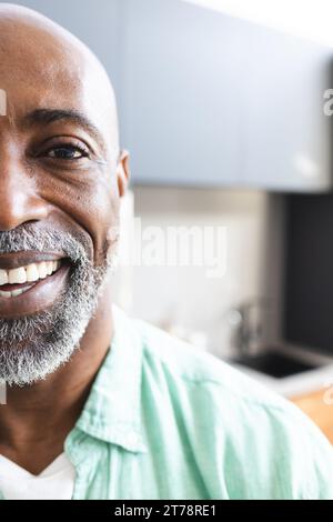 Halbporträt eines glücklichen, kahlköpfigen afroamerikaners, reifer Mann mit Bart, der in sonnigem Raum lächelt, Kopierraum Stockfoto