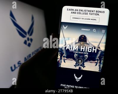 Person mit Smartphone und Website der United States Air Force (USAF) vor dem Logo. Konzentrieren Sie sich auf die Mitte des Telefondisplays. Stockfoto
