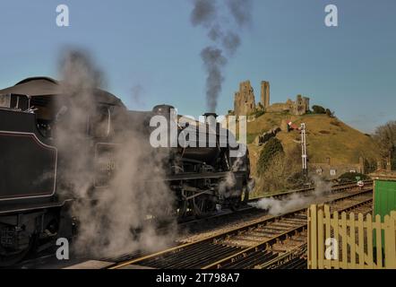 Dampfeisenbahn, die durch den Bahnhof Corfe mit Schloss Corfe fährt Stockfoto