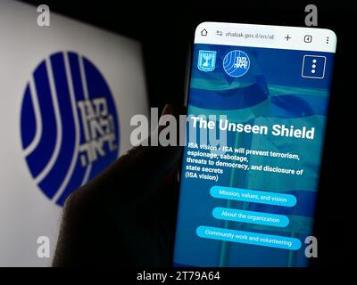 Person, die ein Handy hält, mit Website der israelischen Sicherheitsbehörde (ISA, Shin Bet) vor dem Logo. Konzentrieren Sie sich auf die Mitte des Telefondisplays. Stockfoto