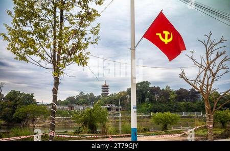 Eine vietnamesische kommunistische Partei Hammer und Sichelflagge neben dem Fluss Ka Long, die über die Grenze in Richtung einer buddhistischen Pagode in Dongxing in Chin blickt Stockfoto