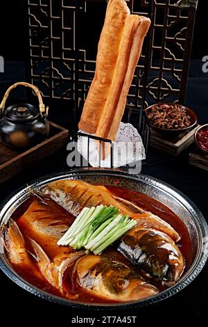 Geschmorter Flussfischkopf mit frittiertem Teigstiel Stockfoto