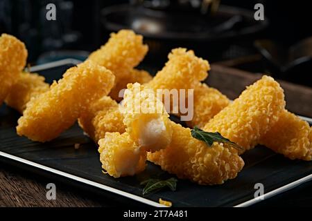 Frittiertes knuspriges Milchdessert，Leche frita oder gebratene Milch auf einem weißen Teller mit süßer Sauce. Stockfoto