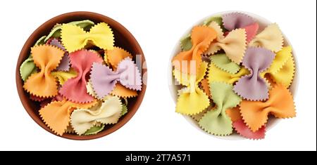 Bunte Farfalle-Pasta in Keramikschüssel isoliert auf weißem Hintergrund mit voller Schärfentiefe. Draufsicht. Flach verlegt. Stockfoto