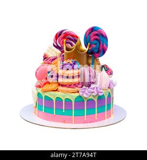 Heller und farbenfroher Kuchen mit goldener Krone, Lutscher, Wirbel, Makronen, Cupcake auf lila Hintergrund. Rosa, blau und violett gestreifter Kuchen Stockfoto