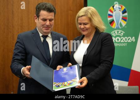 14. November 2023, Berlín: Bundesarbeitsminister Hubertus Heil und Innenministerin Nancy Faeser zeigen die Erklärung, dass die Euro 2024 in Deutschland den UN-Grundsätzen entspricht. Foto: Hannes P. Albert/dpa Stockfoto