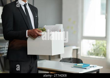 Zugeschnittenes Bild des Unternehmers im formellen Anzug mit Besitztümern Stockfoto