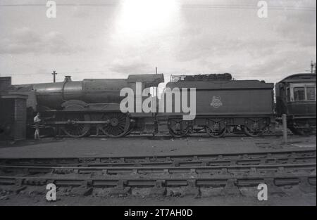 1950er Jahre, historische Seitenansicht einer Dampflokomotive, König Edward VII. Sitzt auf Eisenbahngleisen vor dem Gleisanschluss, England, Großbritannien. Die GWR 4-6-0 King Class Lokomotive wurde 1927 in Betrieb genommen. Sie wurde 1962 zurückgezogen. Stockfoto