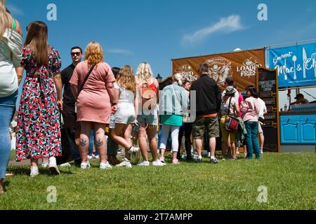 Eine lange Warteschlange von Leuten, die darauf warten, an Einem Fast Food-Stand des Christchurch Food Festivals, Christchurch, Großbritannien, serviert zu werden Stockfoto
