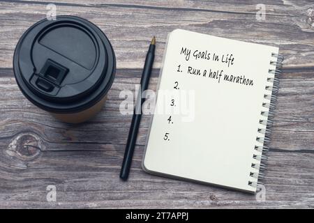 Meine Ziele in der Lebensliste auf Notizblock mit Stift und Kaffee auf Holztisch. Stockfoto